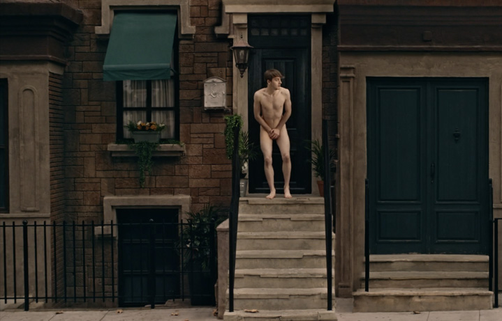 Chico desnudo tapándose la entrepierta en un portal de Nueva York